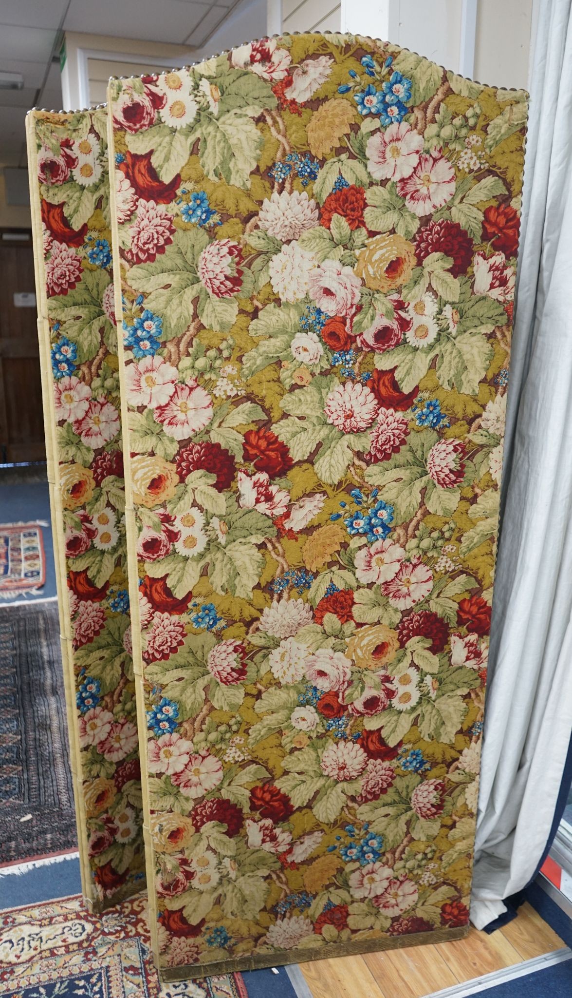 An early 20th century floral fabric four fold dressing screen, each panel width 67cm, height 176cm